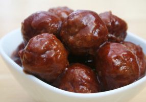 Close  up of glazed meatballs in a white bowl