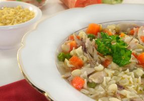 a chicken soup with shell pasta and vegetables